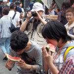 Watching people eat awkwardly-large slices of watermelon