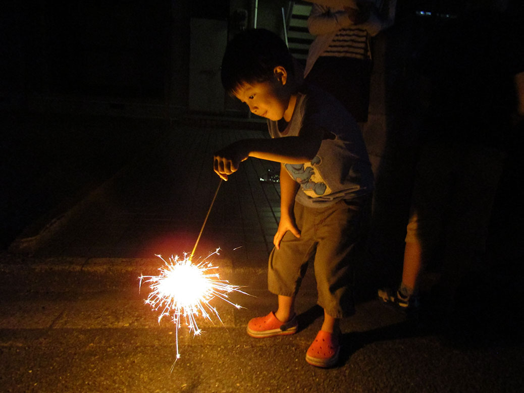 Boy lighting sparklers in the streets of our Japan neighborhood