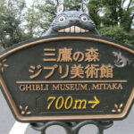 A sign featuring a peeking Totoro points the way to Mitaka City's Studio Ghibli Museum