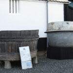 At Kamotsuru Brewery, an old rice steaming vat (right) and its wooden rice basket. This vat could hold three tons of rice and produce 4,000 bottles of sake.