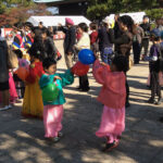 Kids play with balloons while watching the Korean dance performance