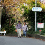 A couple heading toward Satta Pass from Yui Station carry a bag of freshly-purchased oranges