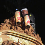 A man sitting atop the float while it's leaning to and fro...