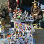 A couple wait patiently for someone to check out their collection of anime character action figures