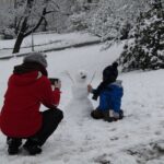 A young boy puts the finishing touches on a snowman in Riegrovy Sady.