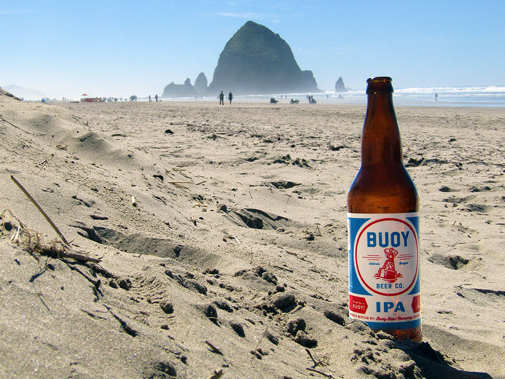 Buoy Beer Company IPA on Cannon Beach with Haystack Rock in the background.