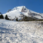 The snow-covered summit of Mount Hood begins to melt by early June.