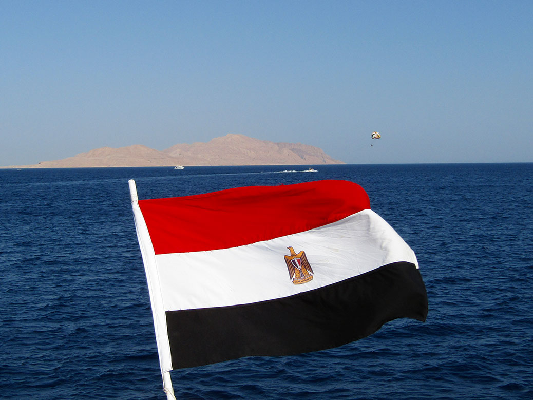 An Egyptian flag with Tiran Island in the distance.