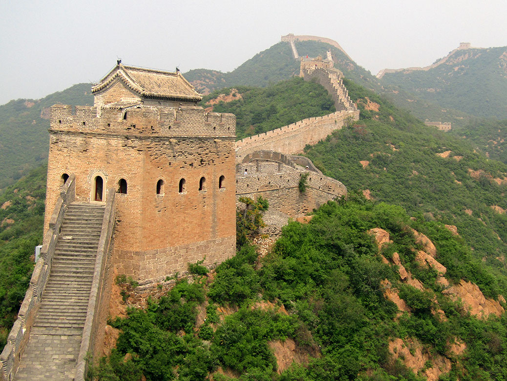 A close up of a guard tower between stretches of fortified wall.